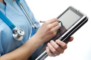 Medical staff holding a tablet recording information