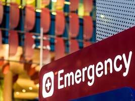 Red and white EMERGENCY sign prominently displayed on a blurry background